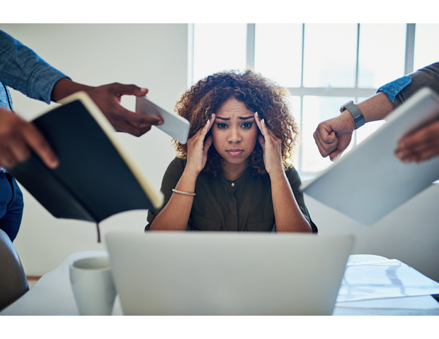 Black woman business owner looking overwhelmed, overworked, and under paid